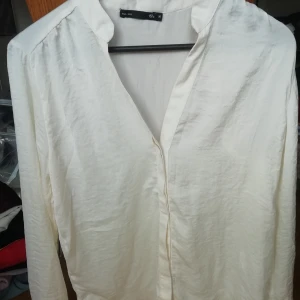 Vit tunn topp  - Vit glansig topp med v-urringning 