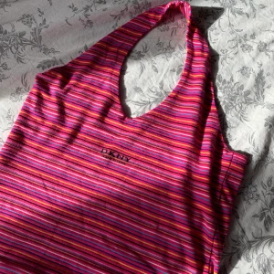 DKNY y2k halterneck topp! - Äkta DKNY halterneck topp. Ett måste för y2k-älskaren! Eller för festen med 00-tema kanske? Hur snygg som helst iaf. Det står att den är i XL men den passar mig som har S. Passar dock större storlekar då den är väldigt strechig. Fri frakt!