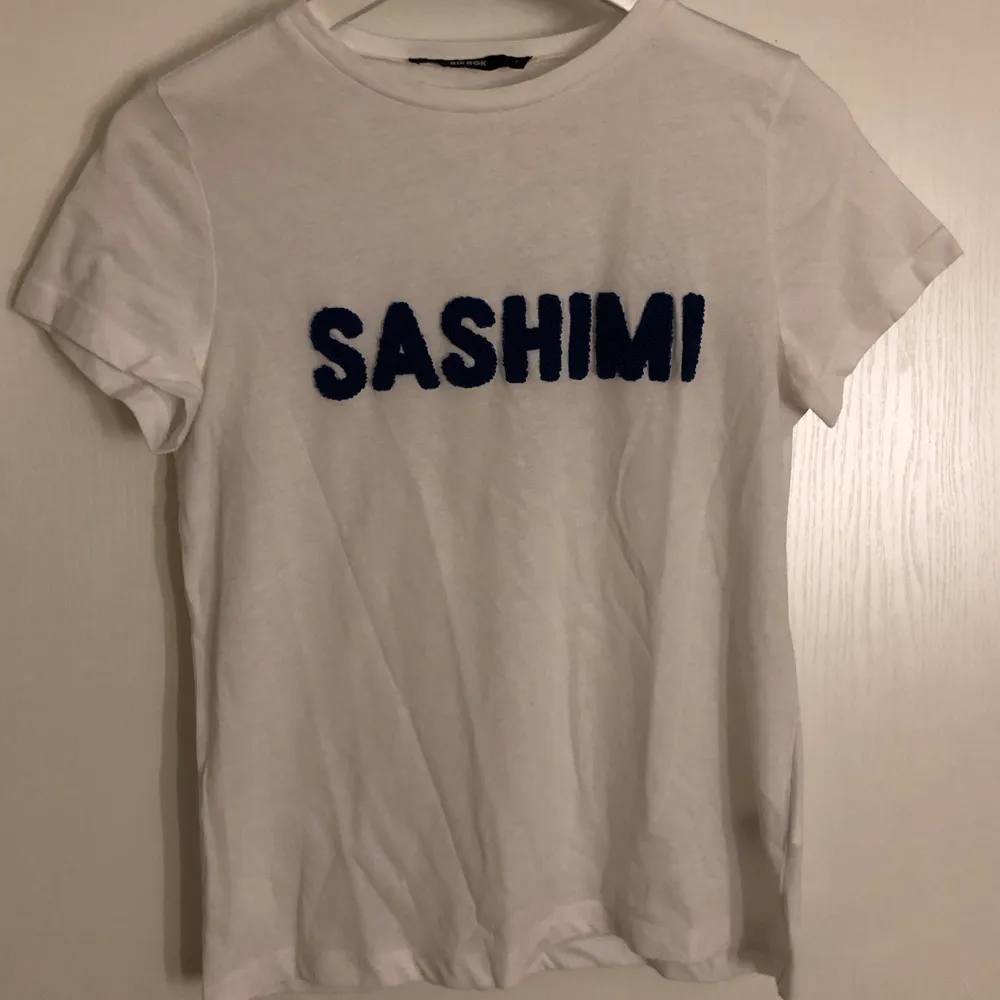 Fin T-shirt med ”SASHIMI” text i coolt material på framsidan. Från Bikbok. Använd en gång och felfri. Frakt ingår😀. T-shirts.