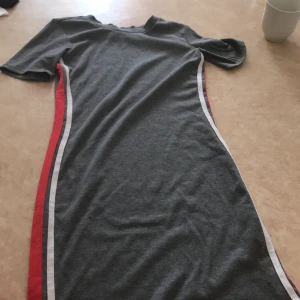 Klänning - en fin sommarklänning lite tajt men ändå väldigt fin. finns en röd och vit detalj på varje sida. frakt inkluderat