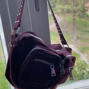 Noella väska  - Säljer min vinröda noella väska pga att den inte kommer till användning, finns ett litet parti i väskans kant som de försvunnit färg men inget man tänker på! 