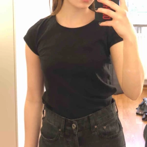  - Basic svart T-shirt i bomull från Hm. Den är i barnstorleken 158-164 men funkar för en som har XS. Finns även en likadan i vit. Kan köpas tillsammans. Köparen står för frakt. 