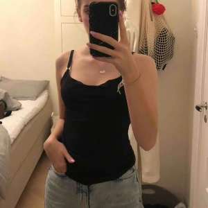 Svart Cowl Neil linne - Säljer mitt bedårande svart linne då det inte kommer till användning längre. Den har små silver detaljer på banden och urringningen är lite lös så den sitter otroligt snyggt över brösten. Använd väldigt sparsamt❤️ Frakt: 42kr