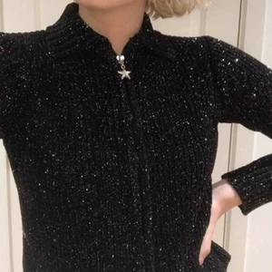  - Superfin svart/silvrig glittrig tröja! Jättefin liten detalj på dragkedjan i form av en stjärna. Passar storlek XS/S beroende på hur du vill att den ska sitta. Skicket är mycket fint och den är knappt använd!