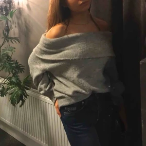  - Grå, stickad off shoulder tröja, bra skick. Inköpt för ett år sedan, säljer pga används inte så mycket. Ganska stor storlek för xs, snyggt med en vit T-shirt under också. ✨☺️ köparen står för frakt