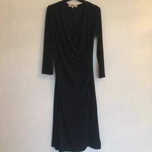 En härlig svart långärmad klänning från Camilla Thulin.
Storlek 40, men passar storlek 38 också.

Figursmickrande omlottmodell. 
95% polyester. 5% spandex.
