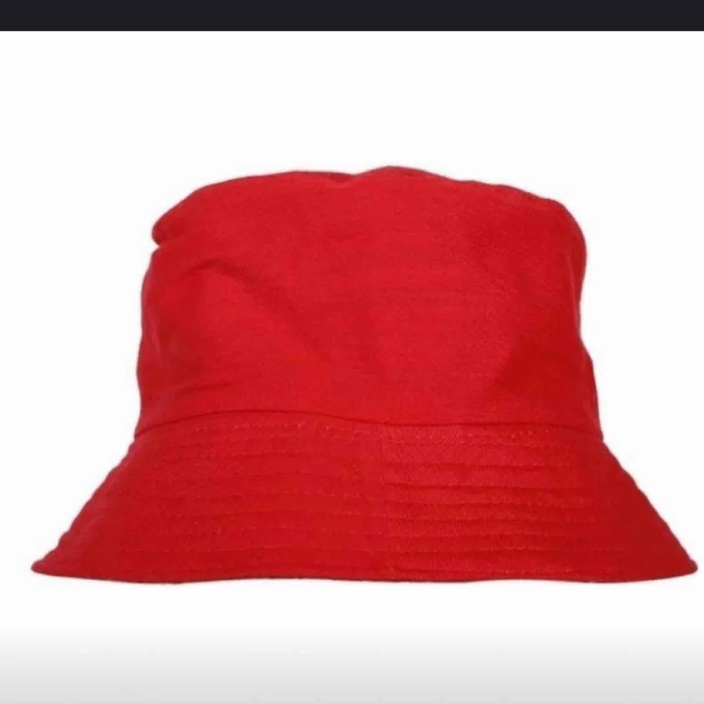 En röd bucket hat. Frakten ingår i priset ✨. Accessoarer.