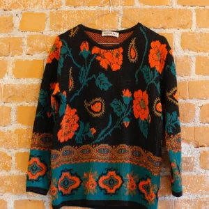  - Stickad tröja i strl S med blommor på svart botten. Använt skick