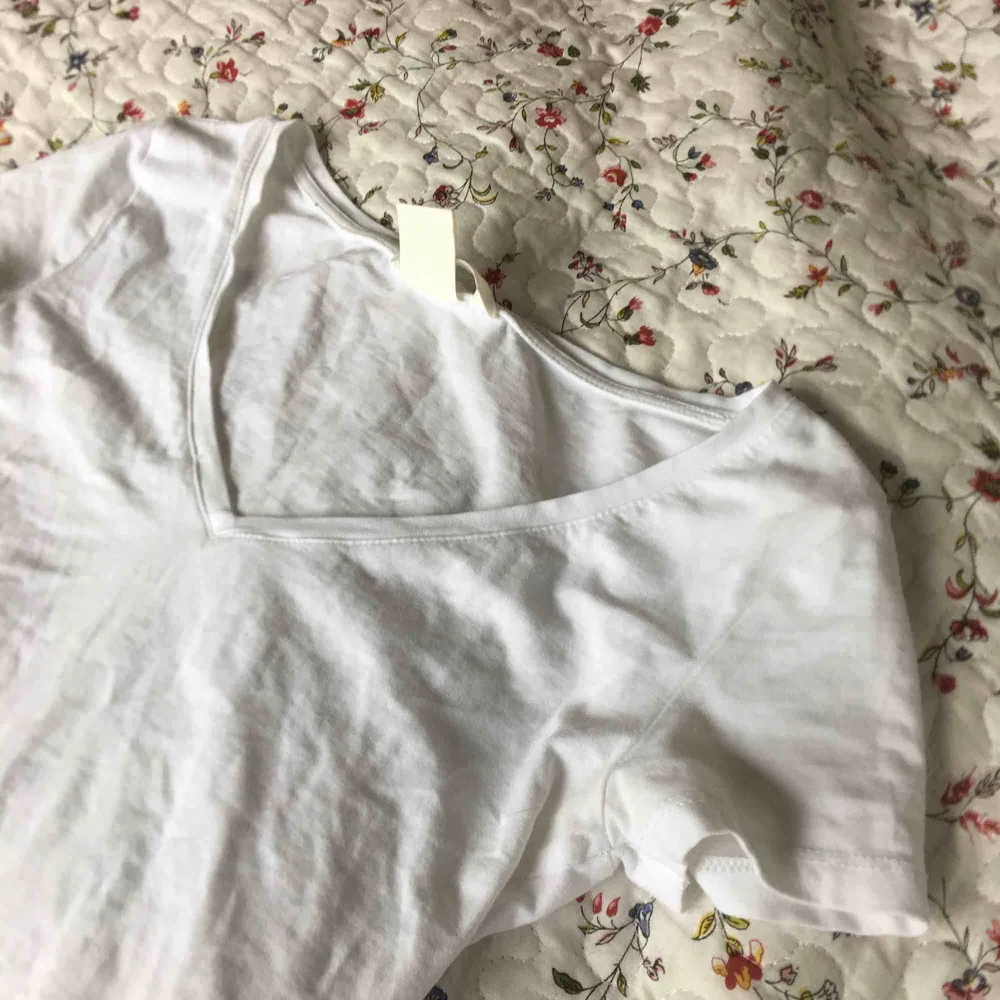 Väldigt tight v-ringad t-shirt i vitt från H&M. Litet hål vid ena ärmen. Lite genomskinlig. Frakt tillkommer.. T-shirts.