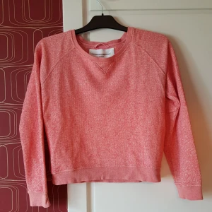  - Fin, hallonrosa collegetröja i lite grövre tyg. Normal passform, ser lite boxig ut på bilden men det är pga galgen. Står 34 på lappen men är lös på mig som är s 36.