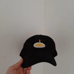  - Keps med ett broderat nudelmotiv. Säljer då jag ge flera svarta kepsar redan. Pris kan diskuteras. Jag bjuder på frakt.