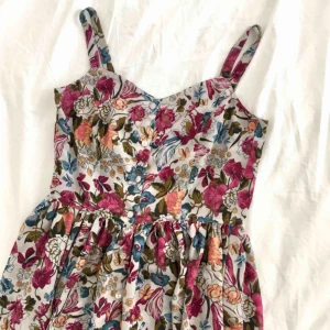  - Blommig klänning med knappar framtill. Lappen är bortklippt men det är storlek XS. 