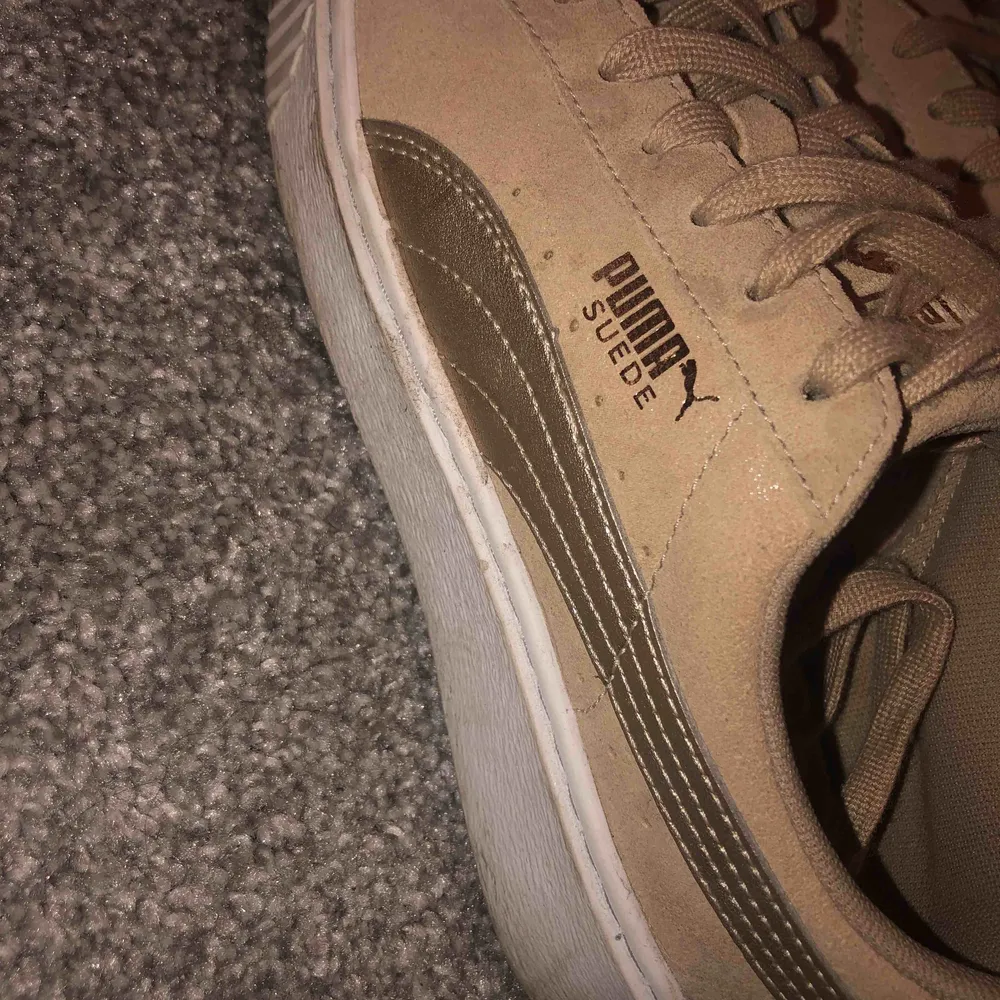 Ett par Puma Plattform i bra kvalite. Använda 1-2 gånger. En mellan beige färg med guldiga detaljer. En lite högre sula. Inköpspris: 1200kr. Skor.