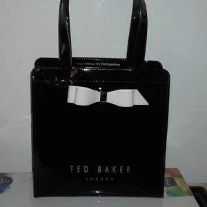  - Äkta Ted Baker ARYCON BOW DETAIL SMALL ICON BAG. Endast använd 1gång så i nyskick! Nypris: 359:- Mitt pris: 299:- och jag bjuder på frakten♡ Köp gärna senast nu på tisdag 29:eOKT-flyttar på onsdag och skickar den gärna till dig innan isåfall(givetvis spårbart).