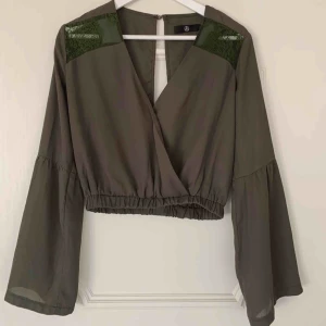  - Riktigt snygg kortare topp i khaki-grön från missguided. Bara använd 2 gånger, i mycket bra skick! Frakt tillkommer  (Om tröjan ser fläckig ut på bilden, så beror detta på dålig kamera och inte tröjan!!) 
