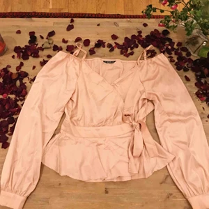  - en superfin oanvänd rosa wrap topp i slätt mönster, i peplum modell och biskopsärmar. säljer pga har en annan topp ungefär liknande denna och den här kommer inte till användning. originalpris 209kr