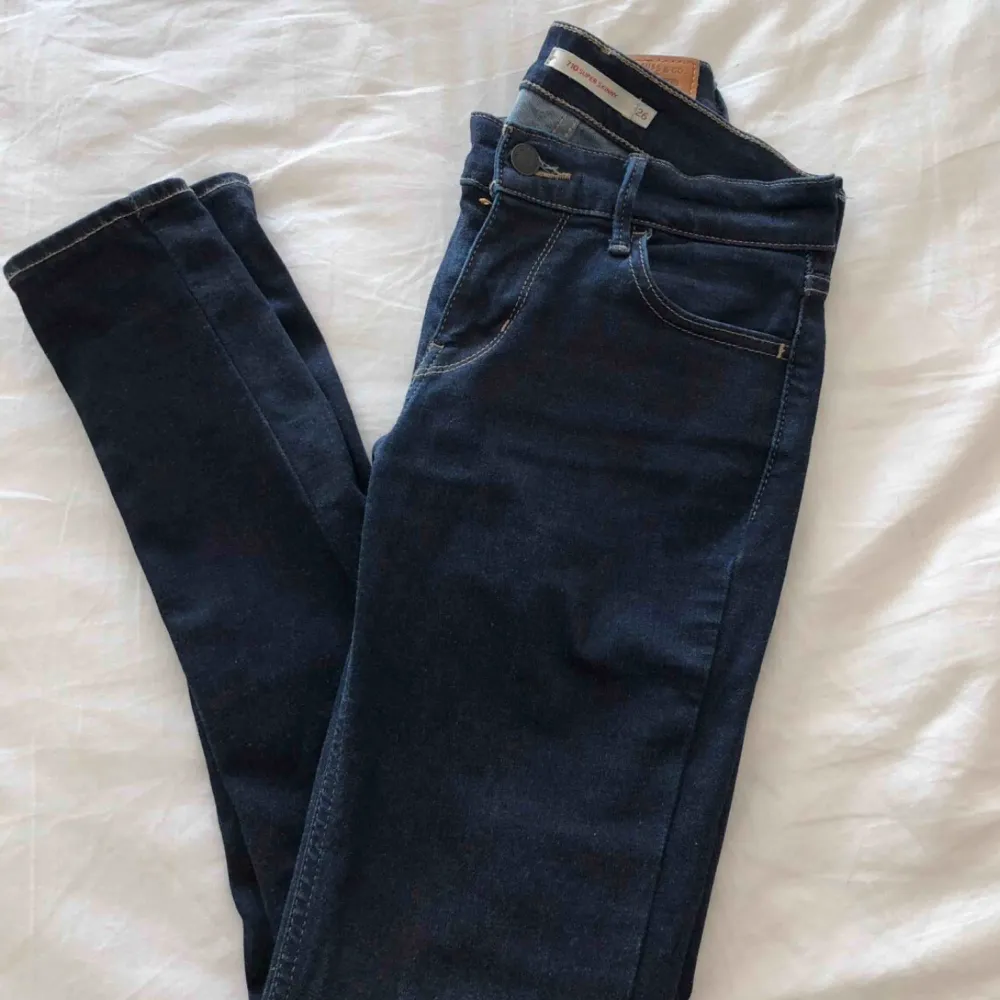 Helt nya jeans i stretchigt material! Super skinny är modellen på jeansen, dom är otroligt sköna och sitter perfekt. Låga i midjan och färgen är mörk blå. Köpta på Levis butik.  Storlek: 26 Original pris: 999kr. Jeans & Byxor.
