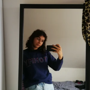 TOMMY HILFIGER (JEANS) TJOCKTRÖJA - Marinblå Tommy Hilfiger sweater med glittrig text. I bra skicka med inget avfallande glitter trots maskintvätt. 