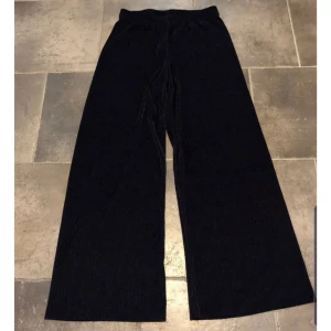  - Snygga vida plisserade byxor från Saint Tropez. Storlek S men kan även passa en med Storlek M. Resår i midjan.  Innebenslängd 83 cm. De benämns som svarta i butiken men jag uppfattar färgen lite som mörkblåa ibland i ljuset. Knappt använda! Mycket fint skick. Köparen betalar för frakt. 