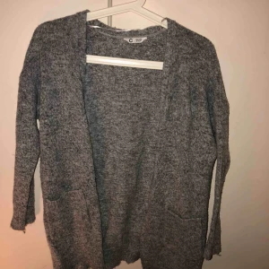  - En supersnygg stilren kofta i grå. Väldigt skönt stickat material. Går lite längre ner beroende på hur lång man är såklart. Fickor på båda sidorna