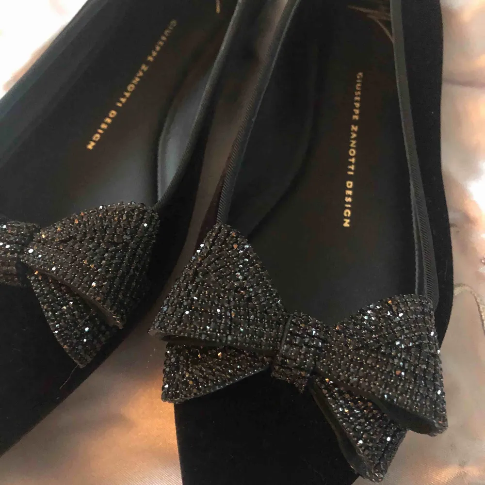 Svarta ballerinas i sammet med glitterrosetter från Giuseppe Zanotti. Köpta för 4900 kr. Använda endast en gång inomhus. Lyfter en hel outfit! . Skor.