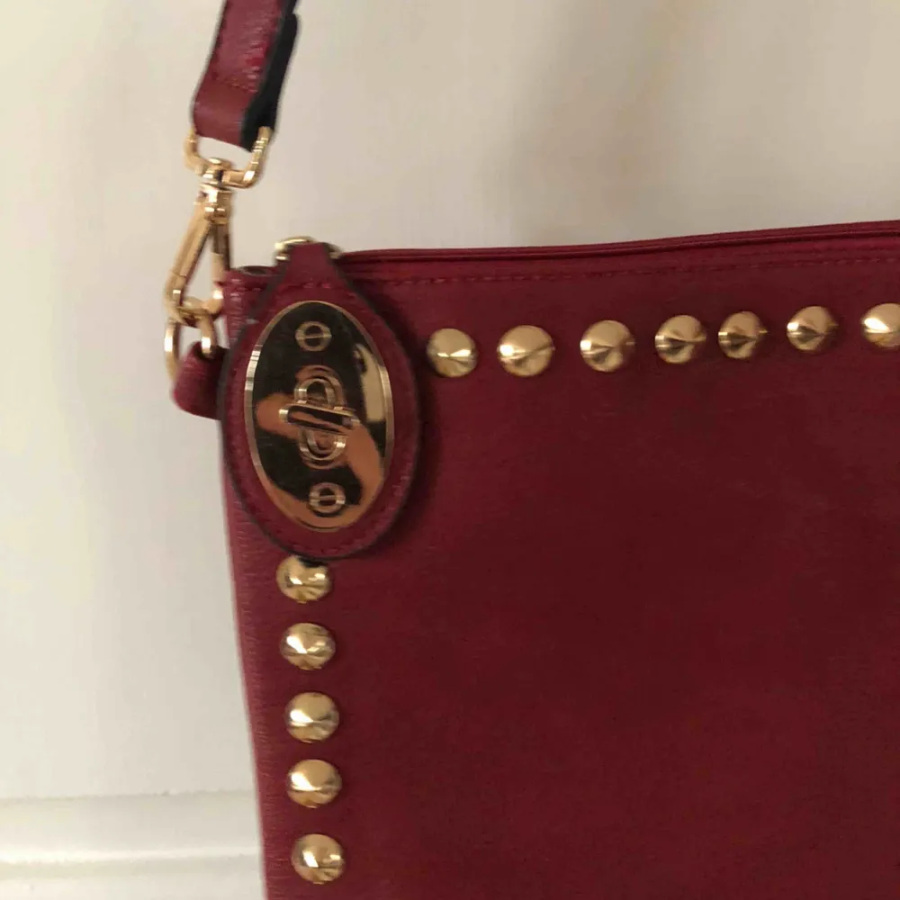 Härlig röd väska med guldiga detaljer❤️❤️ har två olika band så man kan bära den lite olika❤️ har olika fack inuti och är stängbar❤️ aldrig använd!. Väskor.
