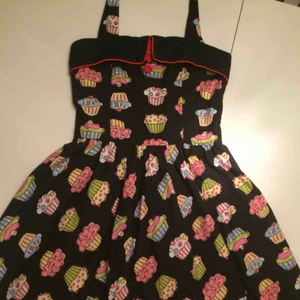  - Svart vintage klänning med cupcakes. Är i bra skick, frakt ingår