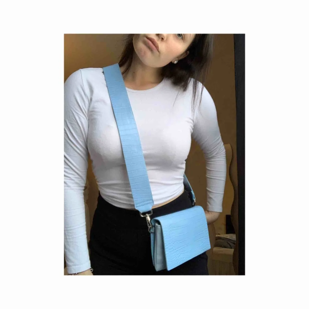 Så fin väska från Carin Wester i en ljusblå färg. Det är ett tjockt band som även går och t av om man vill byta ut det. Nyskick och den är i ”orm” mönster💖. Väskor.