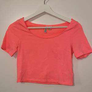 En neon rosa magtröj-T-shirt. Storleken XS men passa även S.