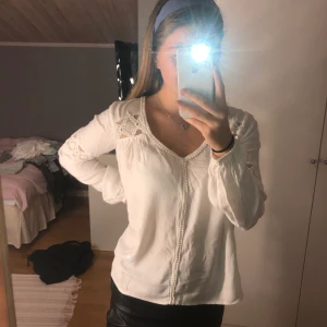 Vit blus med spetsdetaljer - En vit blus från Vila med spetsiga detaljer, väldigt fin i ryggen. Storlek S🥰 använd 2 gånger så nästan helt ny
