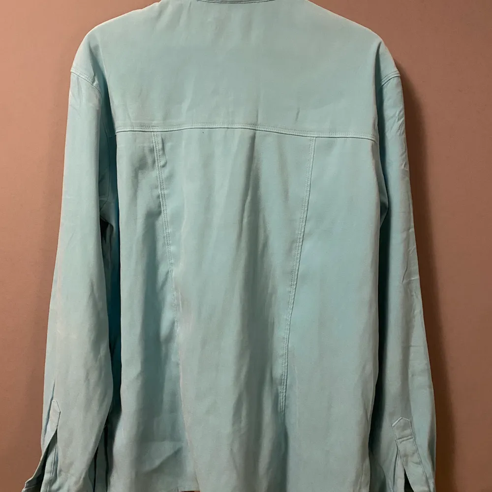 Säljer denna ljusblå/gröna overshirt/skjortan, den har en snygg spetsig krage med två fickor över brösten. . Skjortor.