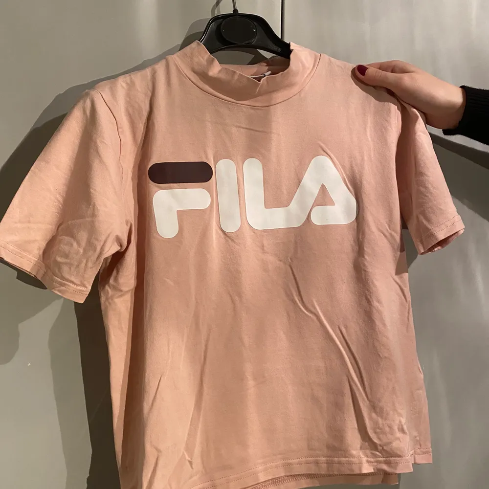 Snygg rosa/beige fila t-shirt i smalare modell med hög krage i storlek M. Smal i modellen så skulle även passa xs och s. T-shirts.