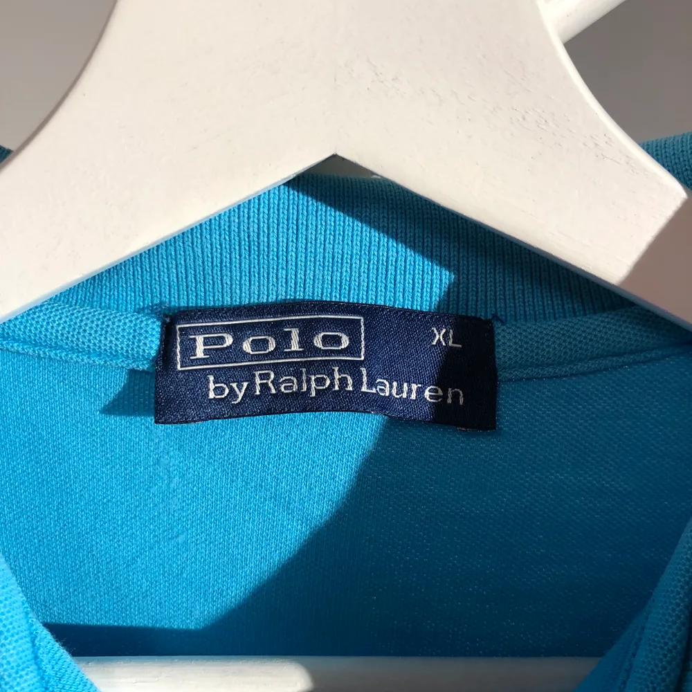 Polo T-shirt i blå, storlek XL, skulle säga den passar en 13 åring, fint skick, trevlig somrig blå färg.. T-shirts.