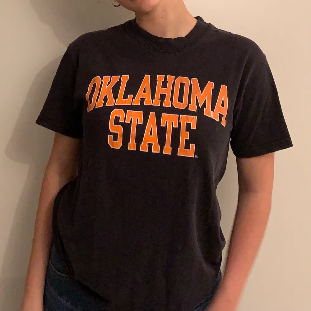 Snygg retro T-shirt med tryck från Oklahoma State🌟 tröjan är mörkblå med oranget tryck. T-shirts.