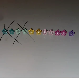 Blomörhängen i olika färger - Jättesöta blomörhängen i ett flertal färger. Alla är i bra skick! Tyvärr har jag tappat det ena lila. De passar jättebra om man till exempel har flera hål att få sätta i de övre. Tar 20kr för de som är i par och 10kr för ett.