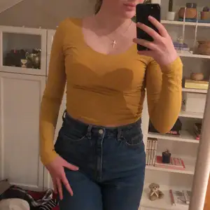 senapsgul långärmad croptop, tillräckligt lång för att kunna stoppas ner i högmidjade jeans nu i höst (: supermjukt skönt material och en cool färg som passar till det mesta. urringad både fram och bak, supersmickrande