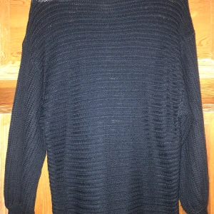 Stickad tröja  - Marinblå stickad tröja med ballongärmar och en längre mudd nere vid ärmslutet!! Köparen står för frakten och det angivna fraktpriset kan ändras! 