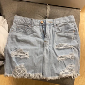 Kjol - En kort och ljus kjol med fina slitningar 