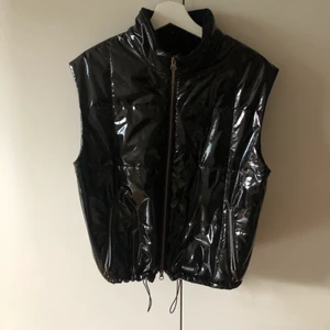 Lackad väst  - Lackad väst med resår ner till. Står ingen storlek men skulle säga att den passar bäst på en XS eller S. Frakt tillkommer!