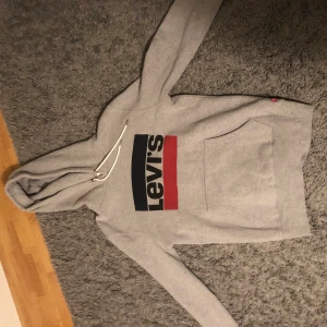 Levi’s Hoodie - Snygg grå hoodie från Levi’s! Köpt för ett tag sen med ett pris på 649kr. Nästan helt oanvänd då jag snabbt växte ur den så skicket är 10/10. Hör av dig vid intresse!