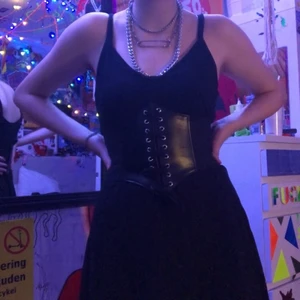 Svart klänning  - Fin svart klänning i filttyg typ, (korsetten är inte till salu) köpt på H&M för typ 100kr i storlek M, typ aldrig använd. Köparen betalar frakt 