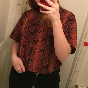 Snakeprint oversized croped t-shirt från topshop - Jättefin oversized croppad t-shirt som är använd med i väldigt gott skick. Säljes p.g.a. för liten. Frakt tillkommer😋