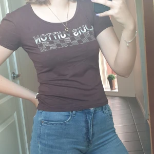 Brun Louis Vuittion t-shirt - En brun louis vuitton t-shirt. Den är i bra skick den ända är att vissa av "diamanterna" har åkt av. 