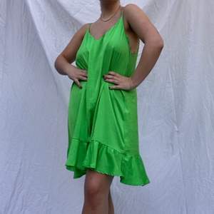En grön, flowy drömklänning! Rak passform med volang i nederkant. Skulle säga att den passar en M-XL beroende på önskad passform 