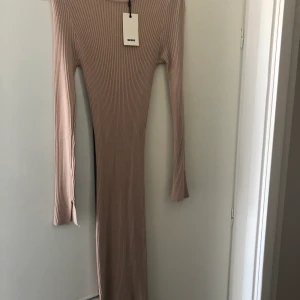 Helt ny klänning  - Säljer denna super fina lång klänning i beige/brun färg, ribbstickad och sitter tajt på kroppen. Storlek Medium HELT NY! Nypris 299kr säljer den för 150kr 
