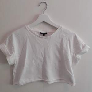 En vit croppad t-shirt från Topshop som sitter lite större under brösten. Frakt ingår i priset💋