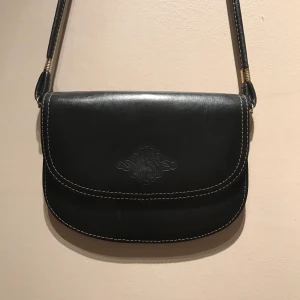 Vintage väska  - Vintage svart väska i jätte fin stick! Köpt för 200 kr men säljer pga rensar garderoben och aldrig använd! Frakt tillkommer