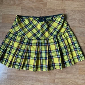 Tripp Nyc rutig kjol - Säljer en helt oanvänd gul rutig kjol av märket Tripp Nyc. Köpt för 650kr, men den har helt enkelt inte kommit till användning och behöver ett nytt hem. Den passar storlek M-S. Frakt ingår.