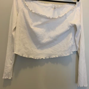 Off shoulder topp - Vit off shoulder topp från hm. Aldrig använd. Skön och stretchig. Det finns som små gummiband runt tröjan vid axlarna så att tröjan intr glider av, svårt att förklara, skriv för mer funderingar eller bilder. Köparen står för frakt, skriv för om frågor💓💓