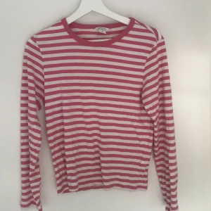 Tröja - En vit och rosa randig tröja ifrån monki. Använd sparsamt. Köpare står för frakten.